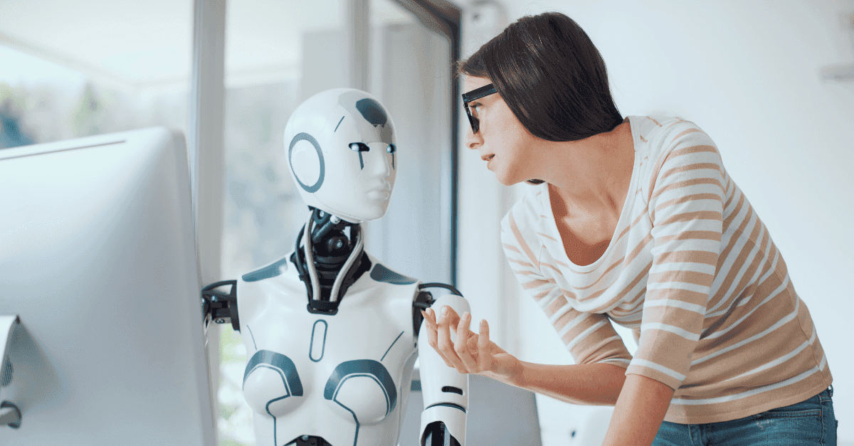 Robot and woman conversing in front of computer